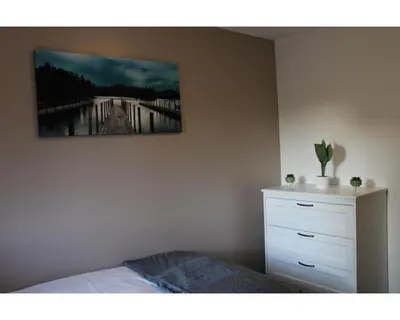 a bedroom with a bed and a painting on the wall at A Comfortable Nest for Contractors or Families - sleeps 8 in Chesterton