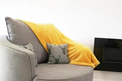 a couch with a yellow blanket on top of it at A Comfortable Nest for Contractors or Families - sleeps 8 in Chesterton