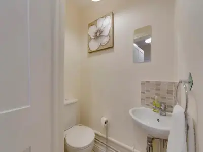 a white bathroom with a toilet and a sink at Pass the Keys Modern and Spacious Terrace in Central Cambridge in Cambridge