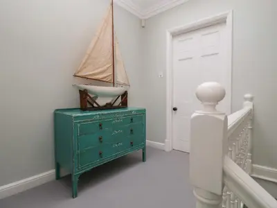 a room with a green dresser and a door at 42 Crag Path in Aldeburgh