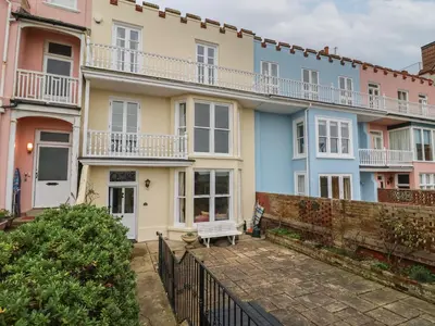 a row of houses with a bench in front of them at 42 Crag Path in Aldeburgh