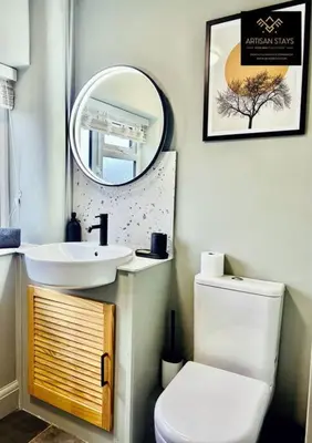a bathroom with a sink and a toilet and a mirror at The Rose Garden of Basildon in the Heart of Basildon by Artisan Stays I Weekly or Monthly Stay Offer I Pvt Parking I Sleeps 6 in Basildon