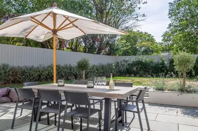 a table and chairs under an umbrella on a patio at Court House, Aldeburgh in Aldeburgh