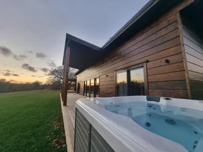 a hot tub on the side of a house at Meadow Valley Lodge 3 - Hot Tub in Hintlesham