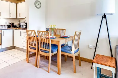 a kitchen and dining room with a wooden table and chairs at Entire 2 Bed Flat Contractors Families and Relocators in Ware
