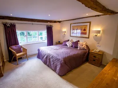 a bedroom with a bed and a chair and a window at Sheene Mill in Melbourn