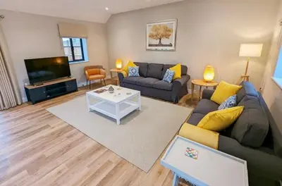 a living room with a couch and a tv at Meadow View Lodges in Bury Saint Edmunds