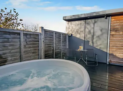 a bath tub sitting on a deck with a table at 1 Bed in Norwich oc-76493 in East Harling