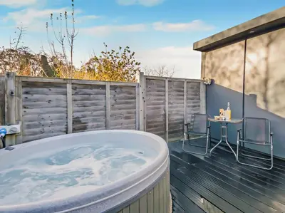 a hot tub on a deck with a table and chairs at 1 Bed in Norwich oc-76493 in East Harling
