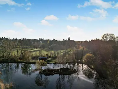 a view of a lake with a church in the distance at 1 Bed in Norwich oc-76493 in East Harling