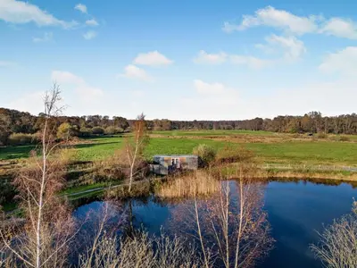 an rv parked in a field next to a pond at 1 Bed in Norwich oc-76493 in East Harling