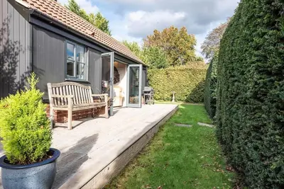 a wooden deck with a bench on a house at The Little House, Orford in Woodbridge
