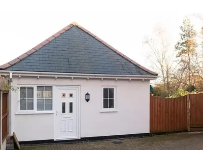 a white garage with a black roof at Colchester Town, modern, detached, guest house in Colchester