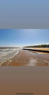 a view of a beach with a pier and the ocean at Cosy Caravan near the beach in Walton-on-the-Naze