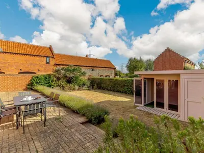 a garden with a table and chairs and a building at 3 Bed in Saxmundham oc-89691 in Aldringham