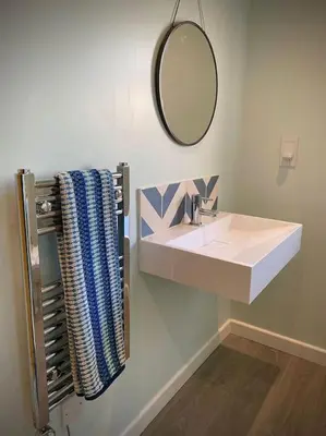 a bathroom with a white sink and a mirror at Bluebell Annexe in Little Grandsen