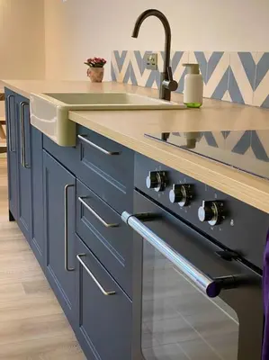 a blue kitchen with a sink and a counter at Bluebell Annexe in Little Grandsen