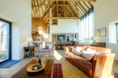 a living room with a couch and a table at Upper Barn - a large family house by Aldeburgh Coastal Cottages in Ufford