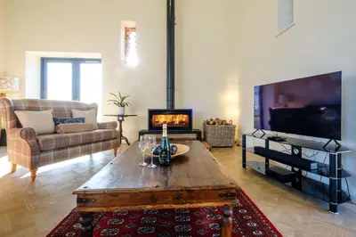 a living room with a coffee table and a fireplace at Upper Barn - a large family house by Aldeburgh Coastal Cottages in Ufford