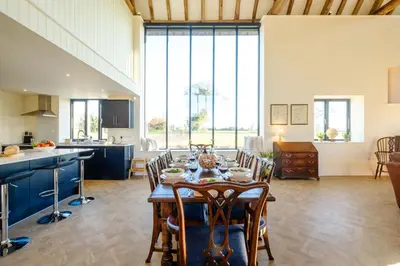 a kitchen and dining room with a table and chairs at Upper Barn - a large family house by Aldeburgh Coastal Cottages in Ufford