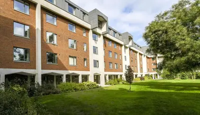 an apartment building with a lawn in front of it at Selwyn College, Cambridge in Cambridge
