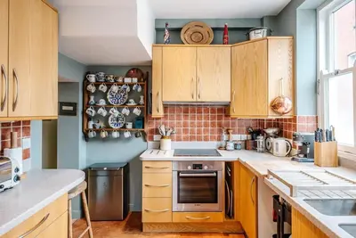 a kitchen with wooden cabinets and a stove top oven at 29 Wentworth Road, Aldeburgh in Aldeburgh