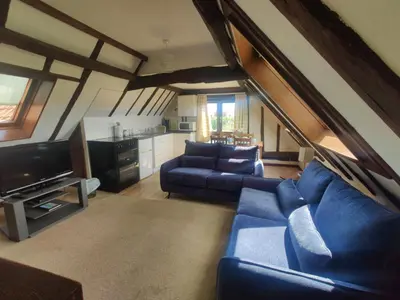 a living room with a blue couch and a tv at Birds Farm in Colchester