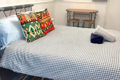 a bed with two pillows on top of it at House - Sleeps 10 - Garden - Parking in Romford