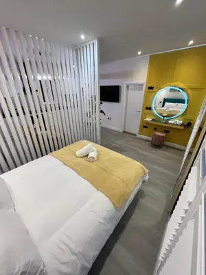 a bedroom with a large bed with a yellow wall at Stylish Studio in Colchester