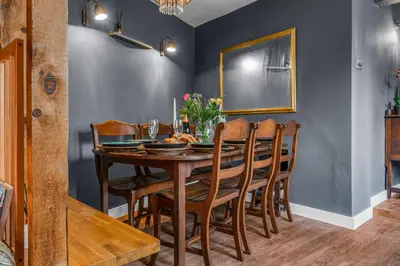a dining room with a wooden table and chairs at The Blue Anchor House - close to London in Hertford