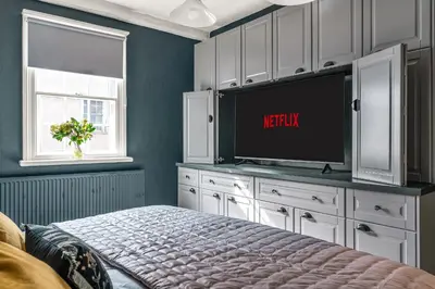 a bedroom with a bed and a tv on a cabinet at The Blue Anchor House - close to London in Hertford