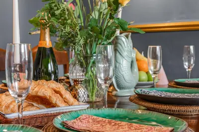 a table with plates of bread and wine glasses at The Blue Anchor House - close to London in Hertford