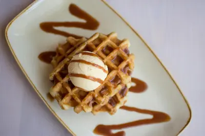 a plate with a waffle with ice cream on it at Dragonfly Hotel Bury St Edmunds in Bury Saint Edmunds