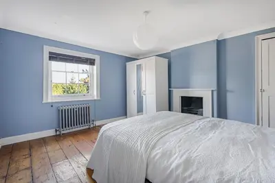 a blue bedroom with a bed and a window at London- Large Period Town House with river front in Hertford