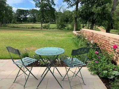 two chairs and a table and a table and chairs at Private 2 Bedroom Apartment at Woodland Retreat in Gamlingay