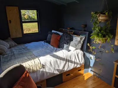 a bedroom with a bed and a window at Blue Sky Huts in Chediston