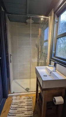 a bathroom with a shower and a sink and a tub at Blue Sky Huts in Chediston