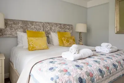 a bedroom with a large bed with towels on it at Fishermans Loft - A seaside house in Thorpeness with direct access to the beach - Aldeburgh Coastal Cottages in Thorpeness