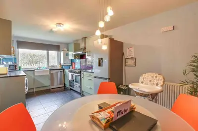 a kitchen with orange chairs and a table with a box on it at Blackwater Terrace Witham in Faulkbourne