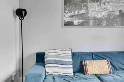 a blue couch in a living room with a picture at Blackwater Terrace Witham in Faulkbourne