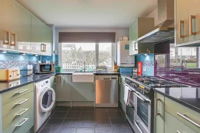 a large kitchen with a washer and dryer at Blackwater Terrace Witham in Faulkbourne