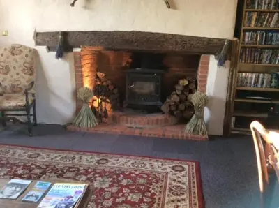 a living room with a fire place with a fireplace at Valley Farmhouse, Westhall in Southwold