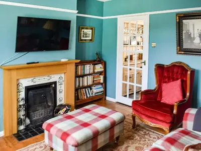 a living room with a fireplace and a tv at Heath View in Saxmundham
