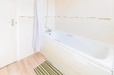 a white bathroom with a tub and a shower at Cambridge 4 Bedroom Sleeps 9 Wi-Fi Garden, LONG STAYS ACCEPTED- Orchid House in Cambridge