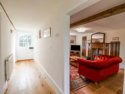 a living room with a red couch and a mirror at West House Farm in Leiston