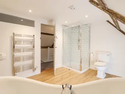 a bathroom with a toilet and a glass shower stall at West House Farm in Leiston