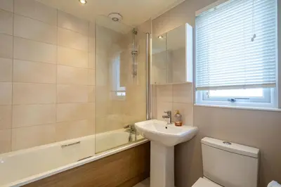 a bathroom with a sink and a toilet and a tub at Sea La Vie in Sizewell
