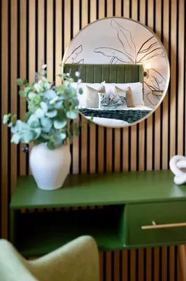 a vase of flowers on a table with a mirror at Luxury Stay, City Walk, Pool Table & Air Hockey, Garden, Parking, Business & Families - Oakview in Colchester