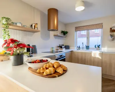 a kitchen with a plate of bread and a bowl of fruit at Luxury Stay, City Walk, Pool Table & Air Hockey, Garden, Parking, Business & Families - Oakview in Colchester