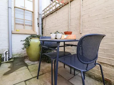 a blue table and chair on a patio at 11a Market Cross Place in Aldeburgh